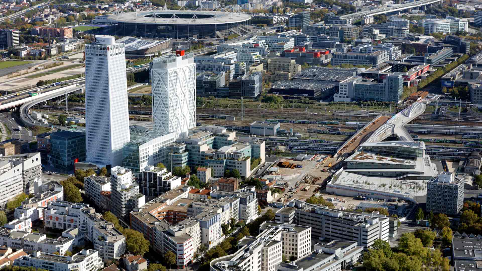 93 Seine-Saint-Denis Paris Region / Saint-Denis: The Pleyel district with the Pleyel Tower / The A86 highway and the Stade de France with the Olympic Aquatics Center in the background / The Grand Paris Express station “Saint-Denis - Pleyel” (interconnection of lines 14, 15, 16 & 17) in the foreground and on the right of the image Ph.Guignard/air-images.net, Direction de l'Observatoire Territorial / Photographer Philippe GUIGNARD (Air Images)